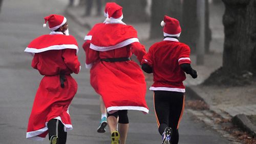 Runners dressed in Santa costumes run in Michendorf, Germany. (AAP)