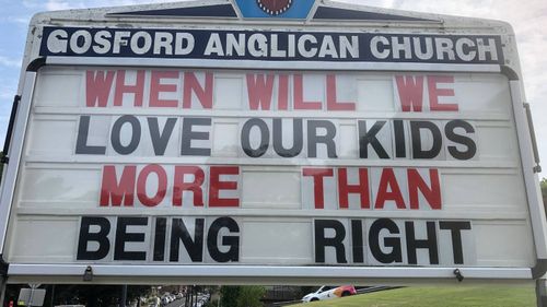 The sign on the roadside by Gosford Anglican Church implored drivers to think about the pill testing debate.