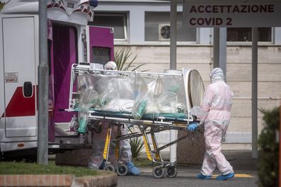 Medical staff collect a patient from an ambulance at the second Covid-19 hospital in the Columbus unit on March 17, 2020, in Rome.