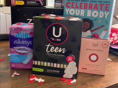 Pads and other menstrual supplies stacked together for a period party.