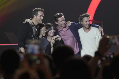 Actor Ryan Reynolds, left, Hugh Jackman, second from right, and director Shawn Levy, right, pose with fans during the red carpet event to promote their latest movie "Deadpool & Wolverine" in Seoul, South Korea, Thursday, July 4, 2024. 