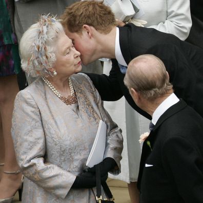 Prince Harry kisses his grandmother, Queen Elizabeth II, as Prince Philip looks on after the wedding of Peter Phillips to Autumn Kelly, at St George's Chapel at Windsor Castle on May 17, 2008 in Windsor, England. 