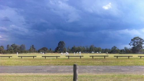 Storm clouds hang over a weekend cricket match at Cessnock in the Hunter. (Amber Huolohan)