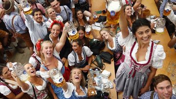 Young women lift glasses of beer during the opening of the 185th &#x27;Oktoberfest&#x27; beer festival in Munich, Germany.