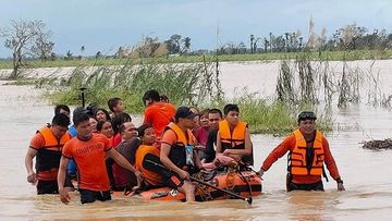 In this handout photo provided by the Philippine Coast Guard, rescuers pull a rubber boat as they assist residents who were trapped in their homes after floodwaters caused by Typhoon Rai inundated their village in Loboc, Bohol, central Philippines on Friday, Dec. 17, 2021. 