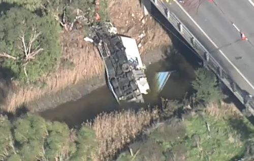 In a third incident, a young truck driver was trapped under his truck after it toppled off a bridge near Melbourne. Picture: 9NEWS.