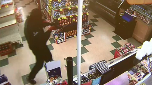 The masked offender was shown pointing a rifle at the teen girl. (9NEWS)