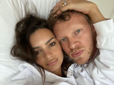 Emily Ratajowski and her husband Sebastian Bear-McClard lying in bed.