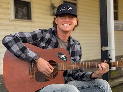 Bailey Zimmerman plays a guitar outside his home in Illinois.