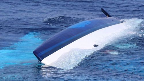 This US Coastguard photo shows Bennett's upturned catamaran with a gash in its hull.