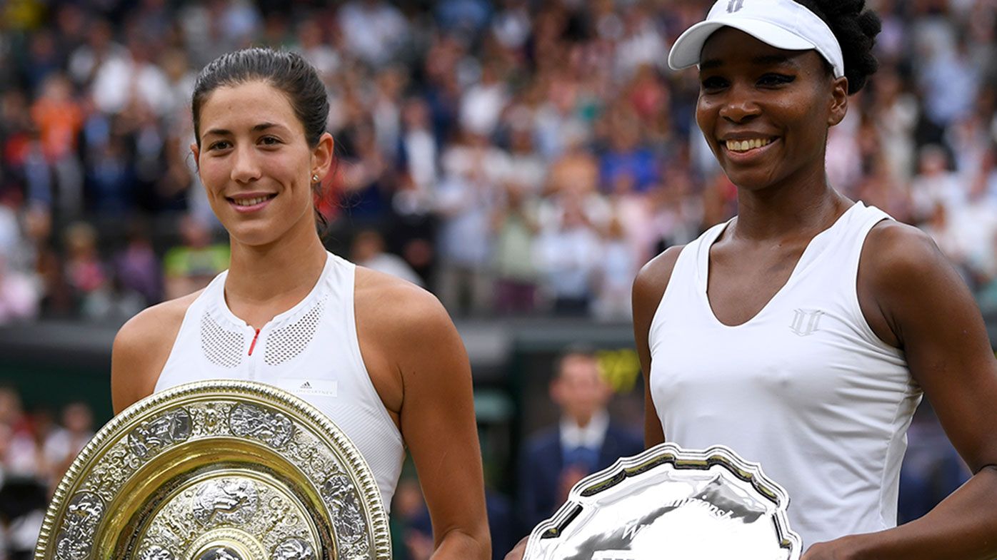 Garbine Muguruza of Spain celebrates victory with the trophy alongside runner up Venus Williams of The United States after the 2017 Wimbledon Ladies Singles final.