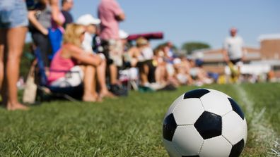 spectators (parents) watching a youth soccer game.
