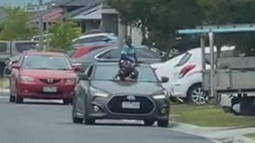 A child has been caught on camera hanging onto a moving car's windshield in Pakenham, Melbourne.