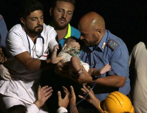 Rescuers pull out 7-month boy Pasquale from the rubble of a collapsed building in Casamicciola, on the island of Ischia, near Naples, Italy, a day after a 4.0-magnitude quake hit the Italian resort island. (AAP)