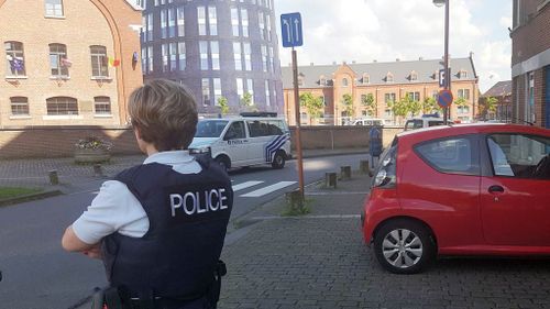 A police officer stands guard close to a police building in Charleroi. (AFP)