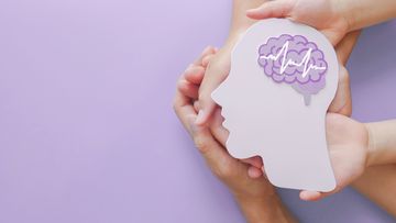 Adult and child hands holding encephalography brain paper cutout,autism, Stroke, Epilepsy and alzheimer awareness, seizure disorder, stroke, ADHD, world mental health day concept