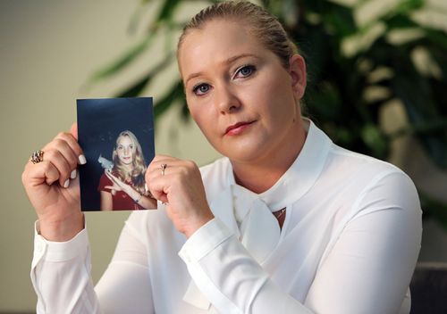 Virginia Roberts Giuffre holds a photo of herself at age 16, when she says now dead Palm Beach multi-millionaire Jeffrey Epstein began abusing her sexually.