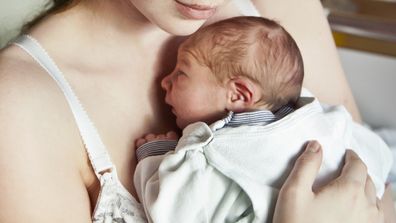 Tired mother holding newborn baby