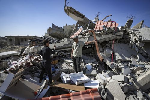 Murad Muqdad, center, stands amid the rubble of his destroyed  home, in Rafah, southern Gaza Strip, Tuesday, Jan. 21, 2025, days after the ceasefire deal between Israel and Hamas came into effect. (AP Photo/Abdel Kareem Hana)