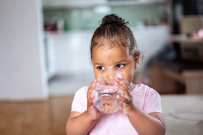 Young girl drinking water.