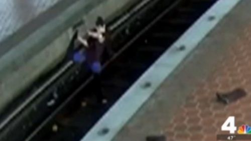 Footage shows the woman fumbling near an electrified track.