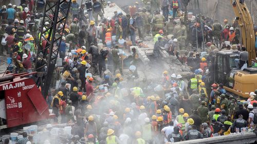 Emergency personnel search for survivors in a collapsed building in Mexico City, Mexico. (AAP)