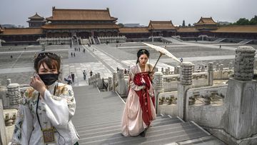 Chinese women dressed in traditional costume known as Hanfu tour the Forbidden City, which recently re-opened to limited visitors, in Beijing, China