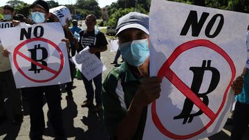 Farmers in El Salvador hold signs emblazoned with messages against the country adopting Bitcoin as legal tender, during a protest in September last year.
