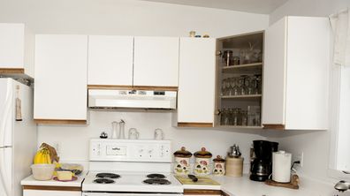white kitchen, refrigerator, stove, sink, sofa, kitchen cabinets