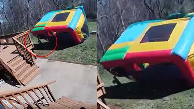 Jumping castle picked up by wind narrowly misses boy. 