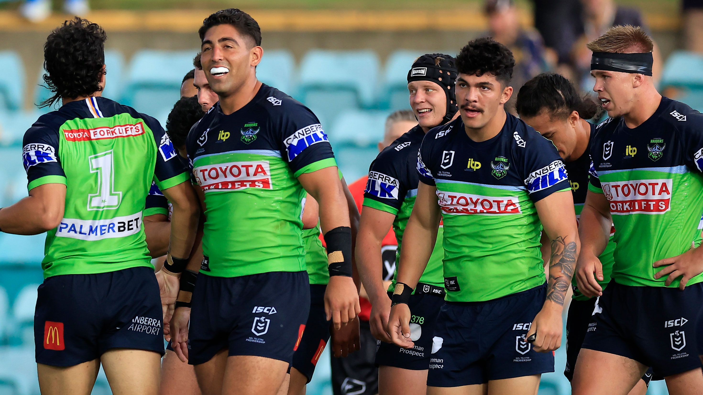 Xavier Savage (left) celebrates a try with Raiders teammates during their trial match against Sydney Roosters.