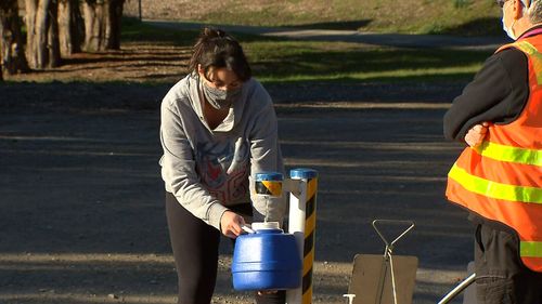 A woman fills up a water bottle because of contamination fears.