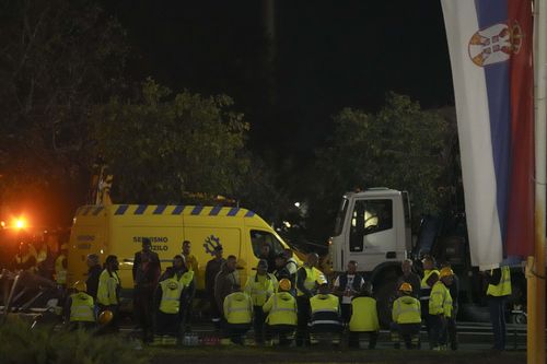 Rescuers rests at the scene after an outdoor roof collapsed at a train station in Novi Sad, Serbia, Friday, Nov. 1, 2024. (AP Photo/Darko Vojinovic)