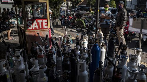 People queue up to refill their oxygen cylinders for Covid-19 patients at a oxygen filling station in Yogyakarta.