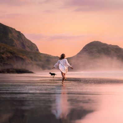 Woman with a dog on the beach, pet-friendly holiday