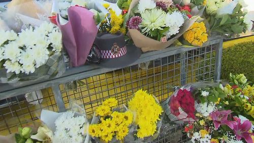 Flowers laid at Campbelltown McDonald's after a paramedic as allegedly stabbed to death by a 21-year-old man.