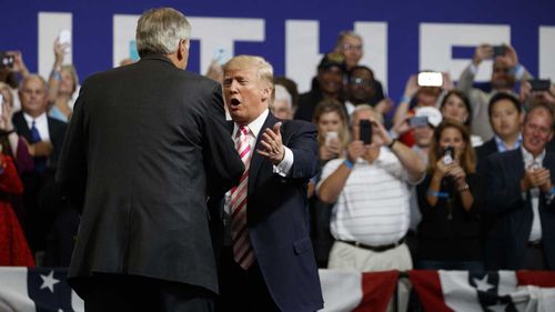 Donald Trump greets the 206cm Luther Strange at a rally. (AAP)