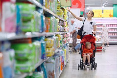 Mother with her boy in baby carriage in the supermarket