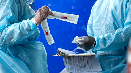 FILE - In this July 23, 2020, file photo, health care workers prepare a COVID-19 test sample before a person self-administered a test at the COVID-19 drive-thru testing center at Miami-Dade County Auditorium in Miami. (David Santiago/Miami Herald via AP)