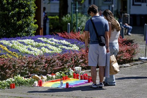 People lay flowers near the scene of a knife attack in Solingen city centre, Germany, Saturday Aug. 24, 2024, after three people were killed and at least eight people were wounded Friday night at the festival 