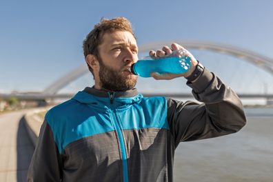 Stock photo of man drinking energy drink.