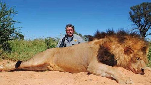 Ernie Dosio com um leão morto em uma caçada anterior.