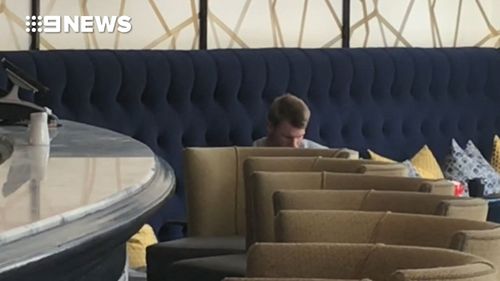 David Warner cuts a silent and lonely figure in the lobby of the Cullinan Hotel in Cape Town just days after the ball tampering bombshell hit the Australian cricket team. (9NEWS)