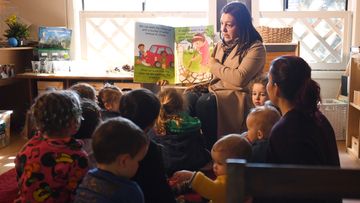 A teacher at a Sydney child care centre reads to young children.