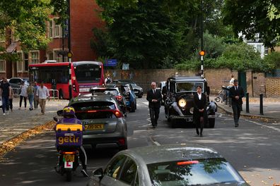 Traffic passes the funeral cortege as it makes its way towards the church ahead of the funeral of Dame Deborah James at St Mary's Church on July 20, 2022 in Barnes, England.  