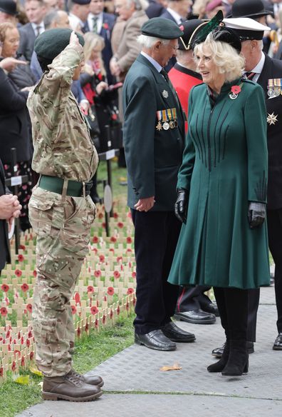 Camilla, Queen Consort smiles as she is saluted by a member of the armed forces at the 94th Year of The Field Of Remembrance at Westminster Abbey on November 10, 2022 in London 