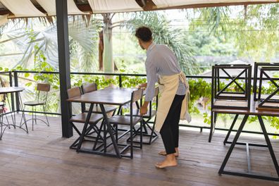 Waiter preparing the coffee shop for opening