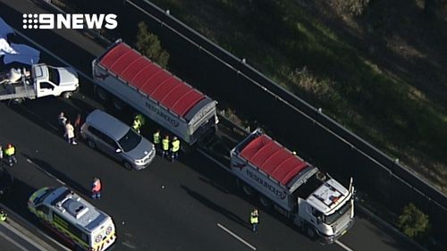 The collision involved a motorcycle and two trucks. (9NEWS)