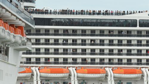 Passengers aboard the MSC Magnifica cruise ship are seen while docked alongside the Golden Princess cruise ship (left) at Station Pier in Melbourne, Thursday, March 19, 2020. 