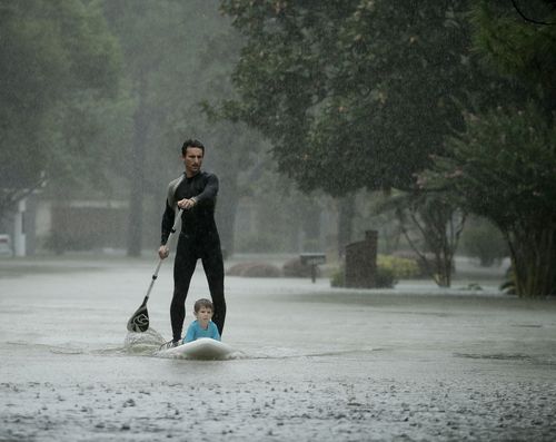 Alexendre Jorge evacuates Ethan Colman, 4, from a neighbourhood inundated by floodwaters in Houston. (AP)